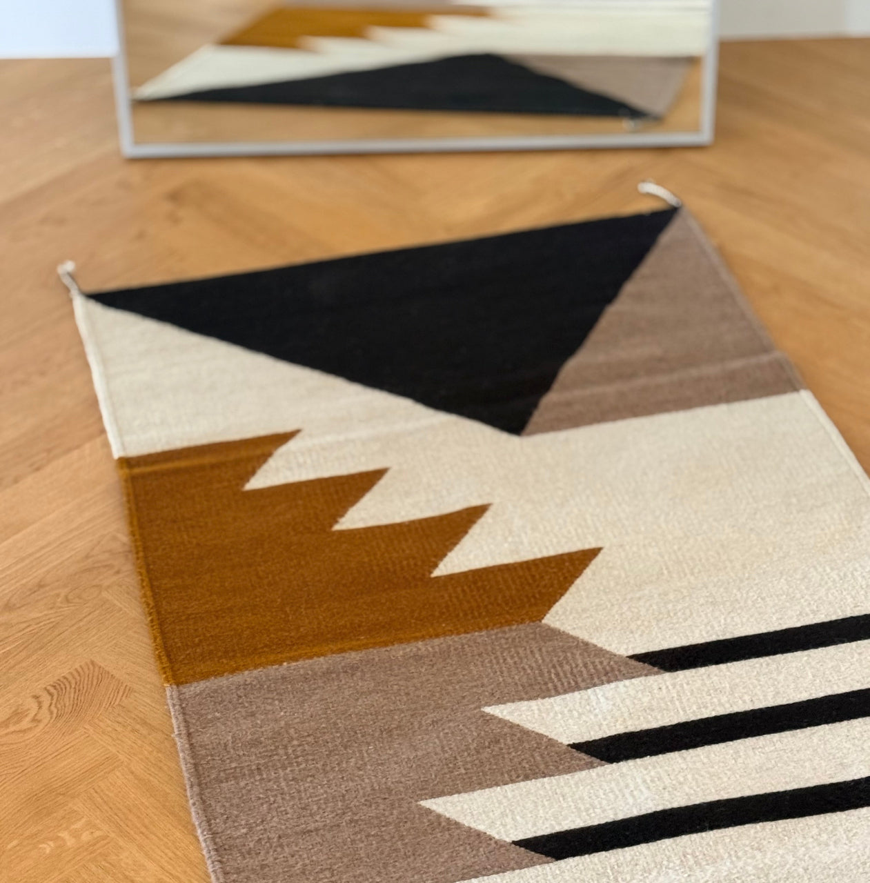 Handmade wool rugs with geometric pattern in black, brown, white and okra color. Rug made in Oaxaca, Mexico by Zapotec weavers. 