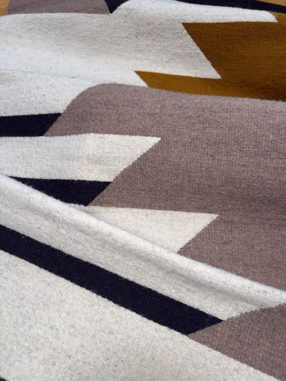 Detail of Handmade wool rugs with geometric pattern in black, brown, white and okra color. Rug made in Oaxaca, Mexico by Zapotec weavers. 